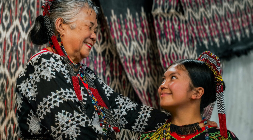 Sebulan Dulay and a young apprentice share a quiet moment — echoing the bond that ties each generation of Tboli weavers